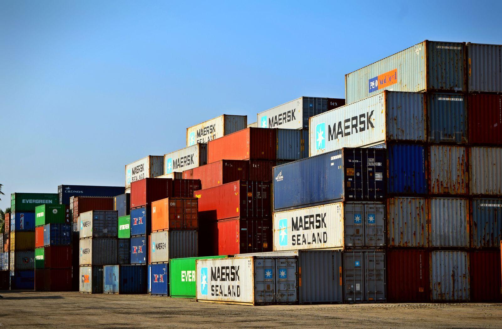 Aerial view of a busy container port with stacked shipping containers