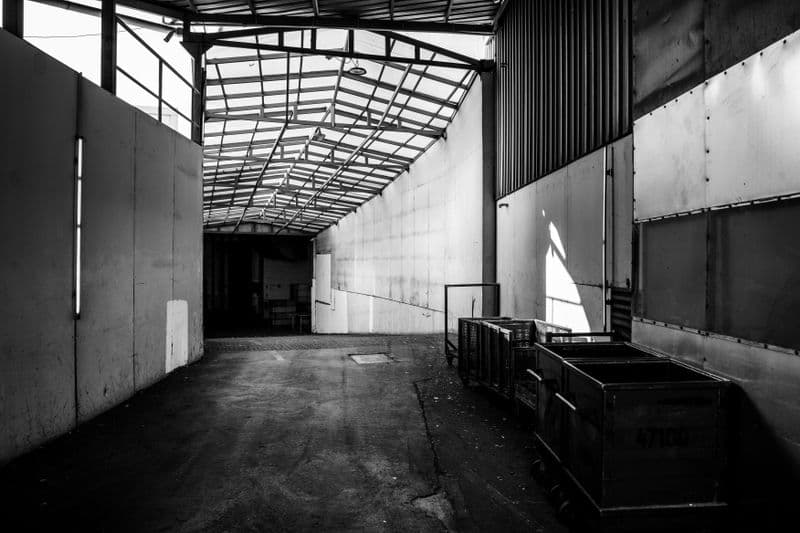 Industrial warehouse corridor with metal cargo bins and careful staging