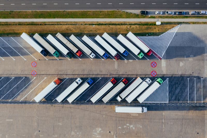 Aerial view of organized freight trucks staged in a logistics yard